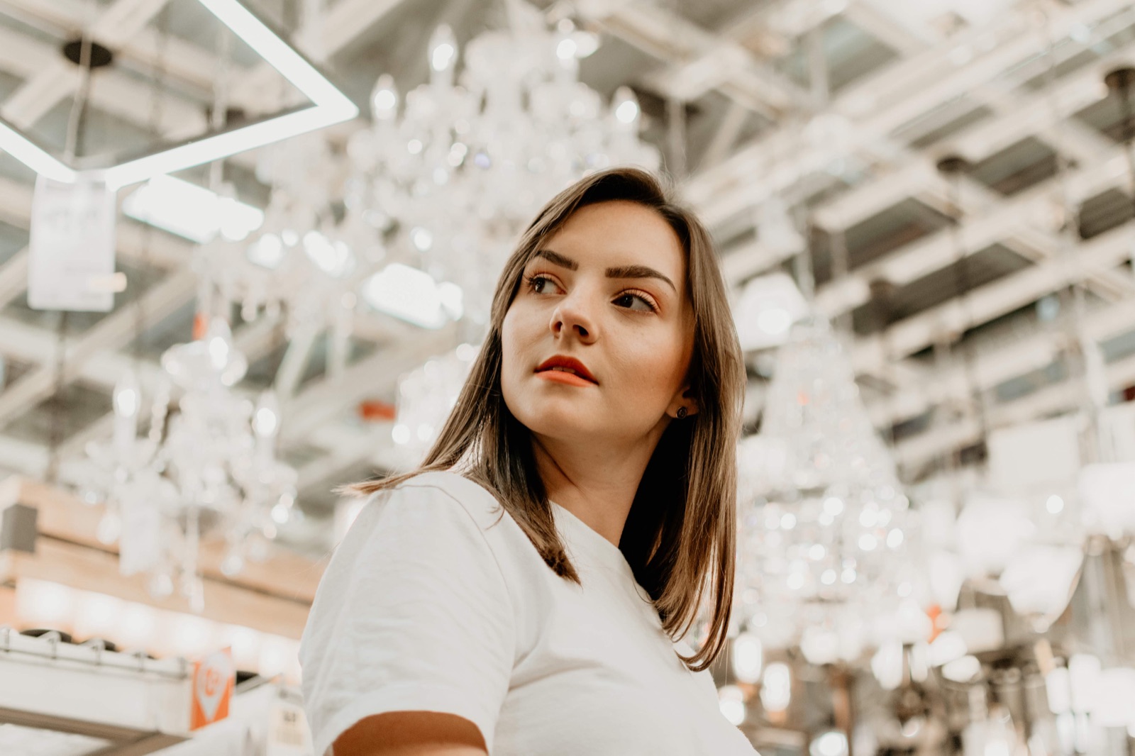 Portrait of a woman beneath rows of crystal chandeliers